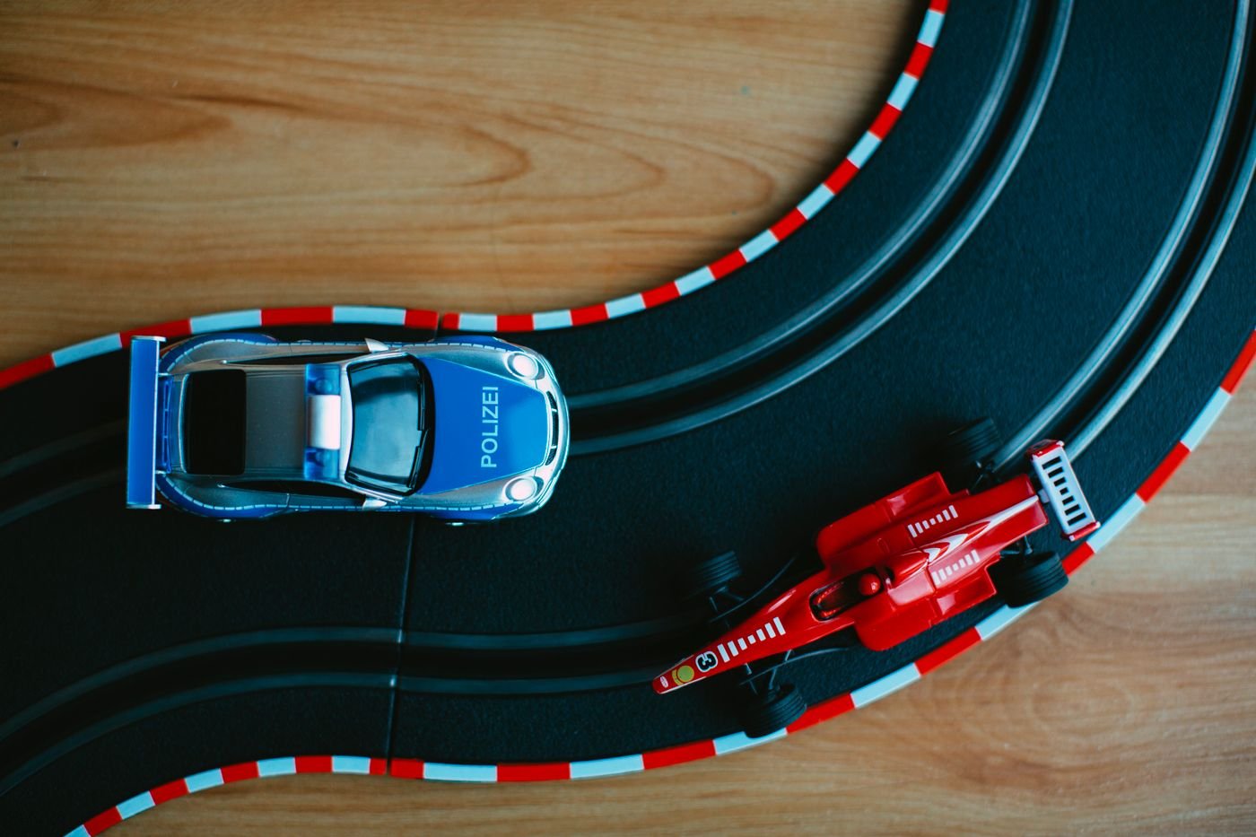 Diecast toy cars arranged on a wooden race track