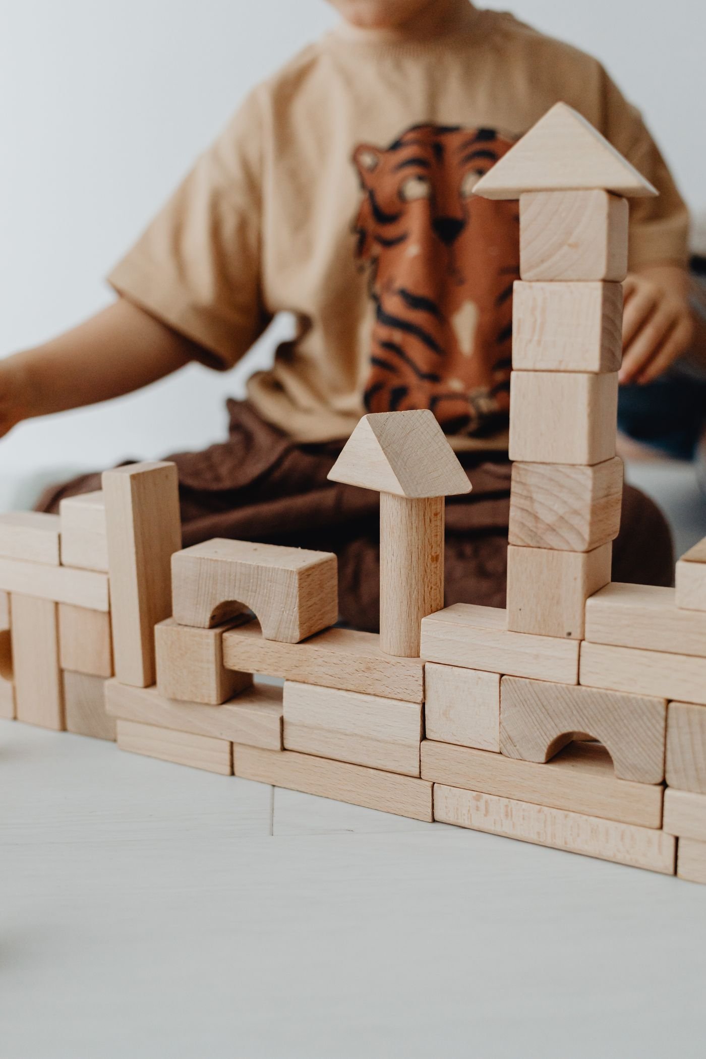Wooden building blocks arranged near a child at play